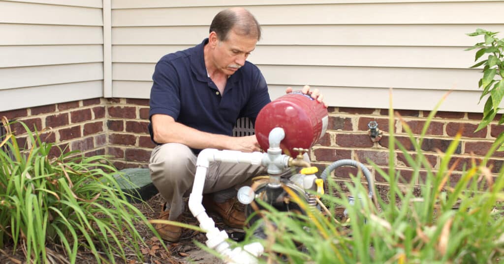 A man wondered, "How do well pumps work," learned, and is now performing maintenance on his well pump.