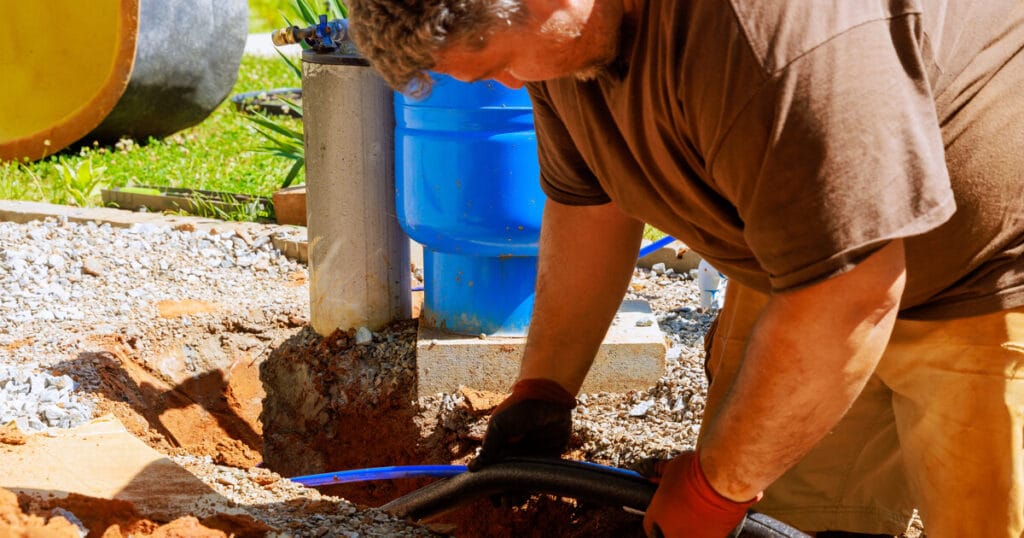 How long should a well pump last? A plumber is taking great care to correctly install a well pump so that it lasts for many years.