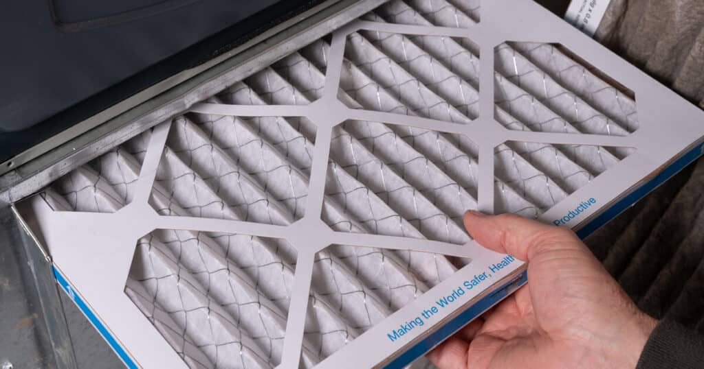 A man replaces his air filter in response to an answer he received to the question, "When to turn ac on?"