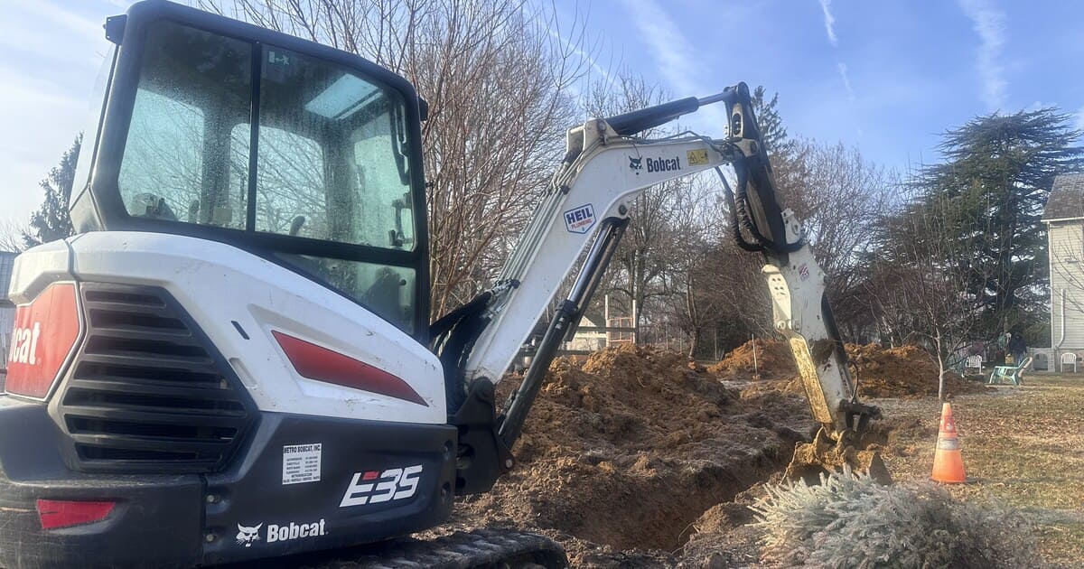 A bobcat from Heil Plumbing & HVAC begins the process of a septic to sewer conversion.