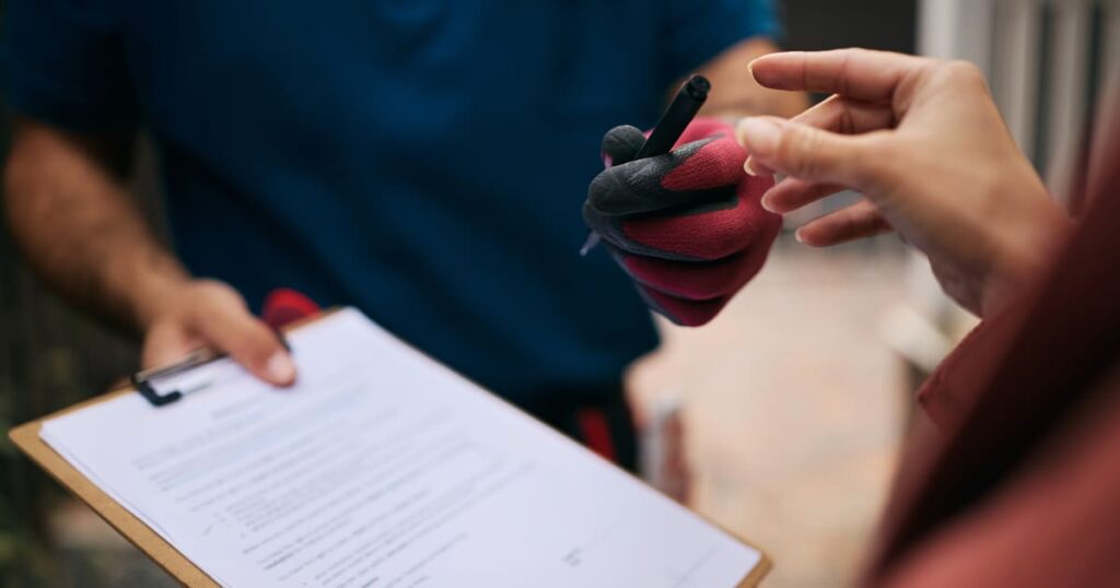 A woman signs an HVAC contract after conducting a window AC unit vs central air cost comparison.