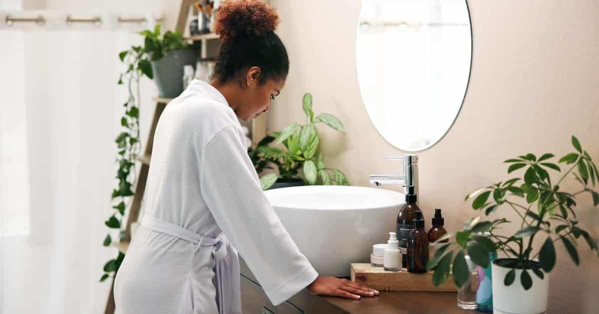 A woman looks into her bathroom sink and thinks, "This bathroom sink smells!"
